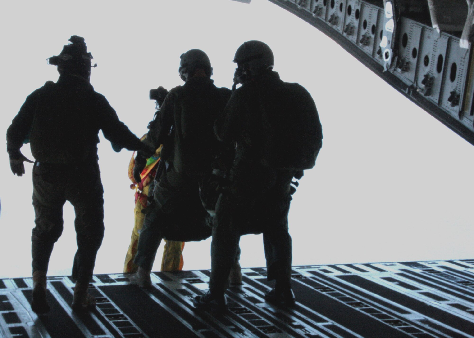 Maj. Aaron Lawson, Special Operations Command, Pacific jumper and special tactics officer, (left) gets the green light for a jump from James Menne, chief of training and readiness for SOCPAC, (right) and Tom Sanders, veteran freefall cameraman and skydiver cinematographer, (who has just exited the plane) just before jumping from a C-17 Globemaster III near Joint Base Pearl Harbor Hickam-Hawaii, Feb. 26, 2013. Sanders was on hand to film the jump as part of an upcoming scene for television show “Hawaii Five-0,” in which the SOCPAC jumpers will serve as stunt doubles for the show’s actors. Sanders exited the plane just before Lawson in order to capture the jump in its entirety. (Photo by James Menne)