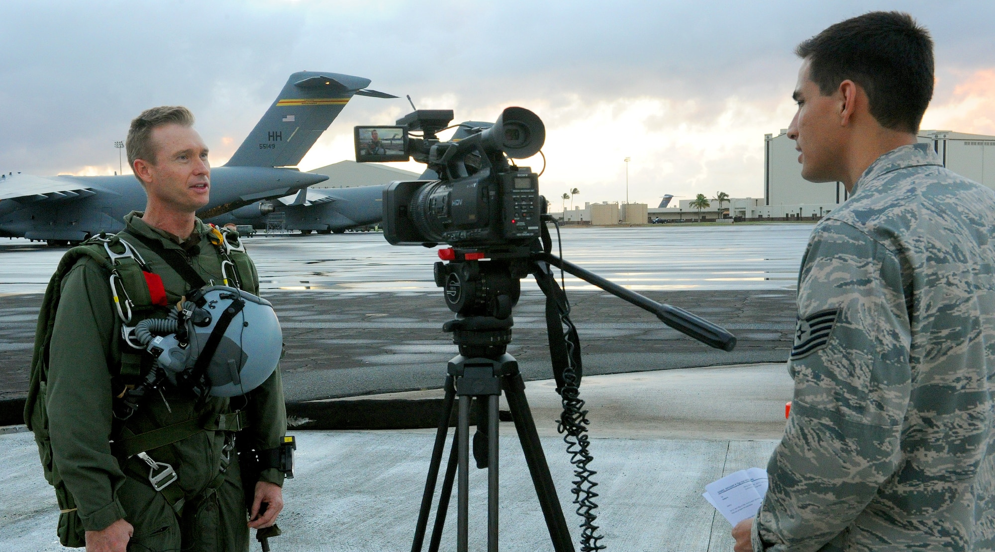 Tech. Sgt. Anthony Gomez, 15th Wing Public Affairs broadcaster (right) interviews Maj. Aaron Lawson, Special Operations Command, Pacific jumper and special tactics officer (left), prior to him performing a freefall jump from a C-17 Globemaster III near Joint Base Pearl Harbor Hickam-Hawaii, Feb. 26, 2013. Lawson was recently given the opportunity to serve as a stunt double for “Hawaii Five-0” actor Alex O’Loughlin. During the interview, Lawson explained the jump procedures for the scene and shared his excitement to be given the opportunity to use his skills as a SOCPAC jumper to fill-in as a stunt double on the show. (U.S. Air Force photo/Tech. Sgt. Jerome S. Tayborn)
