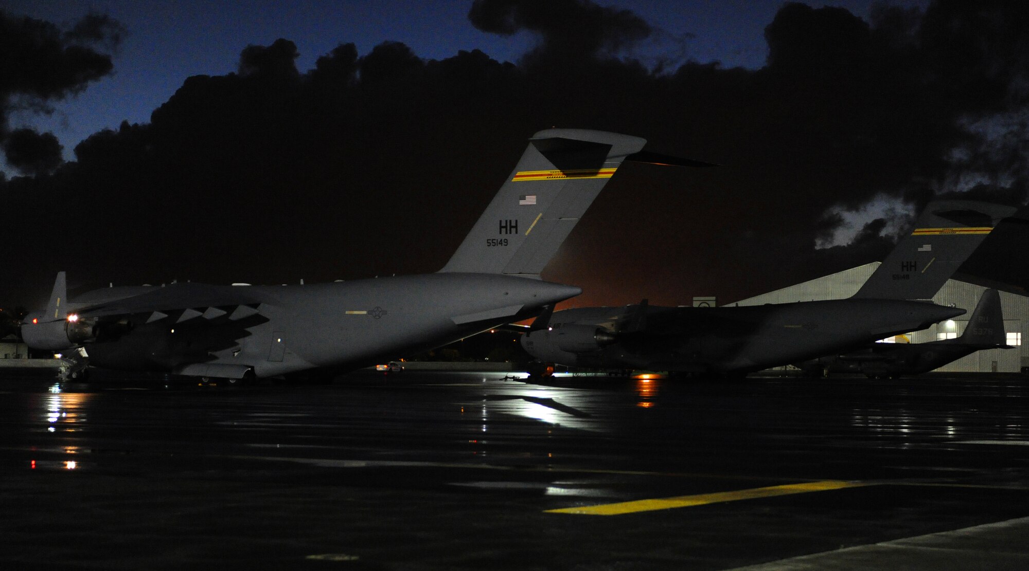 A pair of C-17 Globemaster III’s sit on the flightline at Joint Base Pearl Harbor-Hickam, Hawaii, Feb. 26, 2013. One of the C-17’s was used to film a scene in an upcoming episode of “Hawaii Five-0” in which two Special Operations Command, Pacific jumpers perform a freefall jump as stunt doubles for the show’s actors (U.S. Air Force photo/Tech. Sgt. Jerome S. Tayborn)