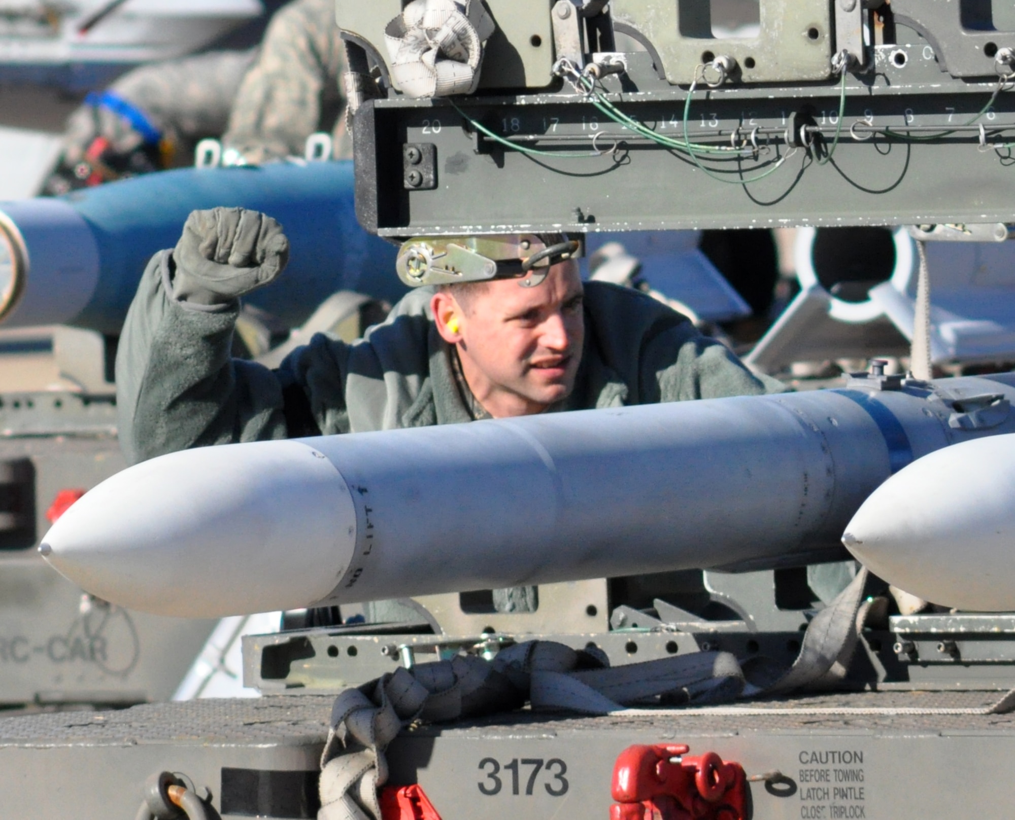 Staff Sgt. Matthew Raesly, 301st Aircraft Maintenance Squadron load team chief and Air Force Reservist, signals the driver of a weapons loader to hold his position while preparing to secure and lift an AIM-120 missile for upload on a 301st Fighter Wing's F-16 during a recent weapons load competition at the Naval Air Station Fort Worth Joint Reserve Station, Texas. (U.S. Air Force photo/Tech. Sgt. Chris Bolen)