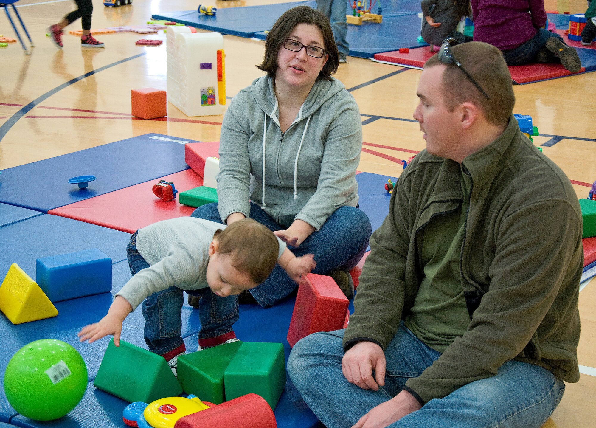 Senior Airman Jason Helbig, 736th Aircraft Maintenance Squadron maintainer, along with his wife Ashley and son Travis play together at the Mommies-N-Me Too group Feb. 21, 2013, at the Youth Center on Dover Air Force Base, Del. There are many activities that parents and children can do together such as an art table, a reading station and open play. (U.S. Air Force photo/ Airman 1st Class Ashlin Federick) 