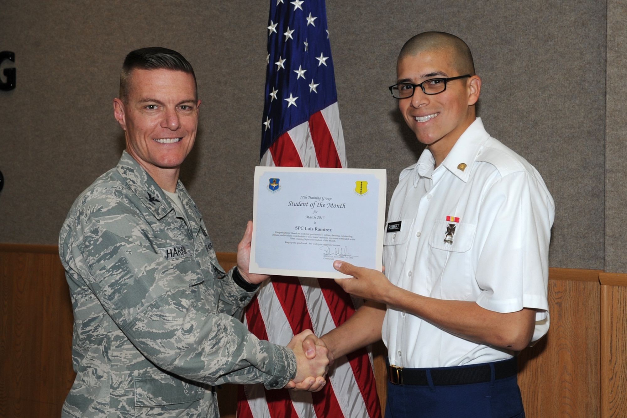 GOODFELLOW AIR FORCE BASE, Texas-- Col. Brendan Harris, 17th Training Group Commander, presents Army Spc. Luis Ramirez with the 316th Training Squadron Student of the Month award for February, March 1. (U.S. Air Force photo/Staff Sgt. Laura R. McFarlane)