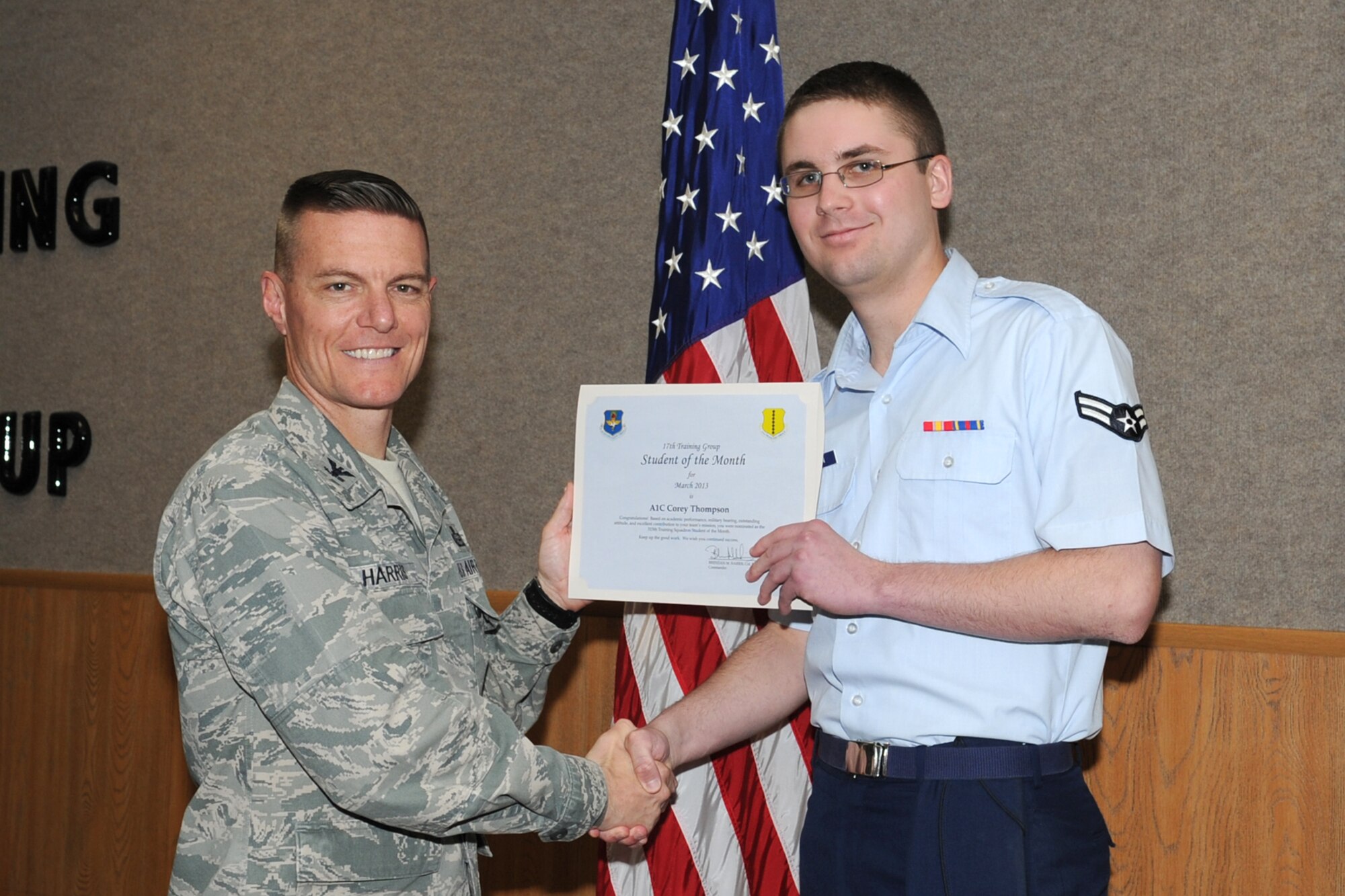 GOODFELLOW AIR FORCE BASE, Texas-- Col. Brendan Harris, 17th Training Group Commander, presents Airman 1st Class Corey Thompson with the 315th Training Squadron Enlisted Student of the Month award for February, March 1. (U.S. Air Force photo/Staff Sgt. Laura R. McFarlane)