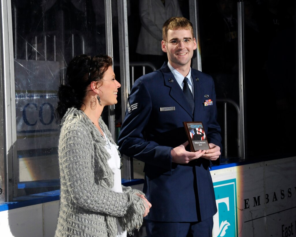 2013 Illinois Outstanding Airman of the Year recipient SrA Alex Corwin is presented an award by Christine Bare of the CIAN Center at the Peoria Rivermen Air National Guard Night on February 23, 2013. (U.S. Air Force photo by SSgt Lealan Buehrer // Released)