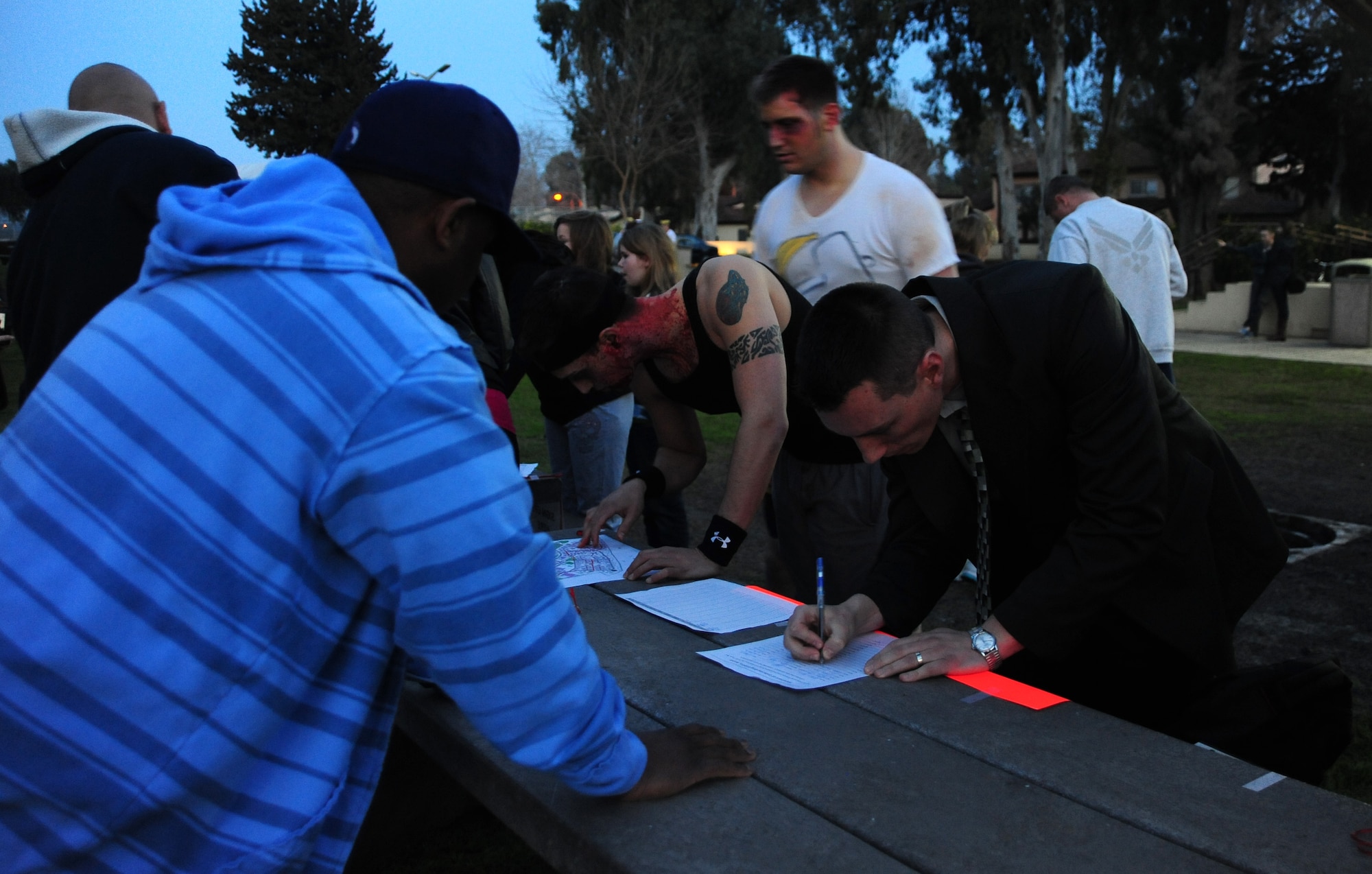 Airmen and families sign up for the 39th Force Support Squadron zombie run March 2, 2013, at Incirlik Air Base, Turkey. The runners could choose to be either a zombie or a survivor upon signing in. Survivors needed to make it through the course before zombies took their three flags, or they would become zombies as well. (U.S. Air Force photo by Senior Airman Anthony Sanchelli/Released)
