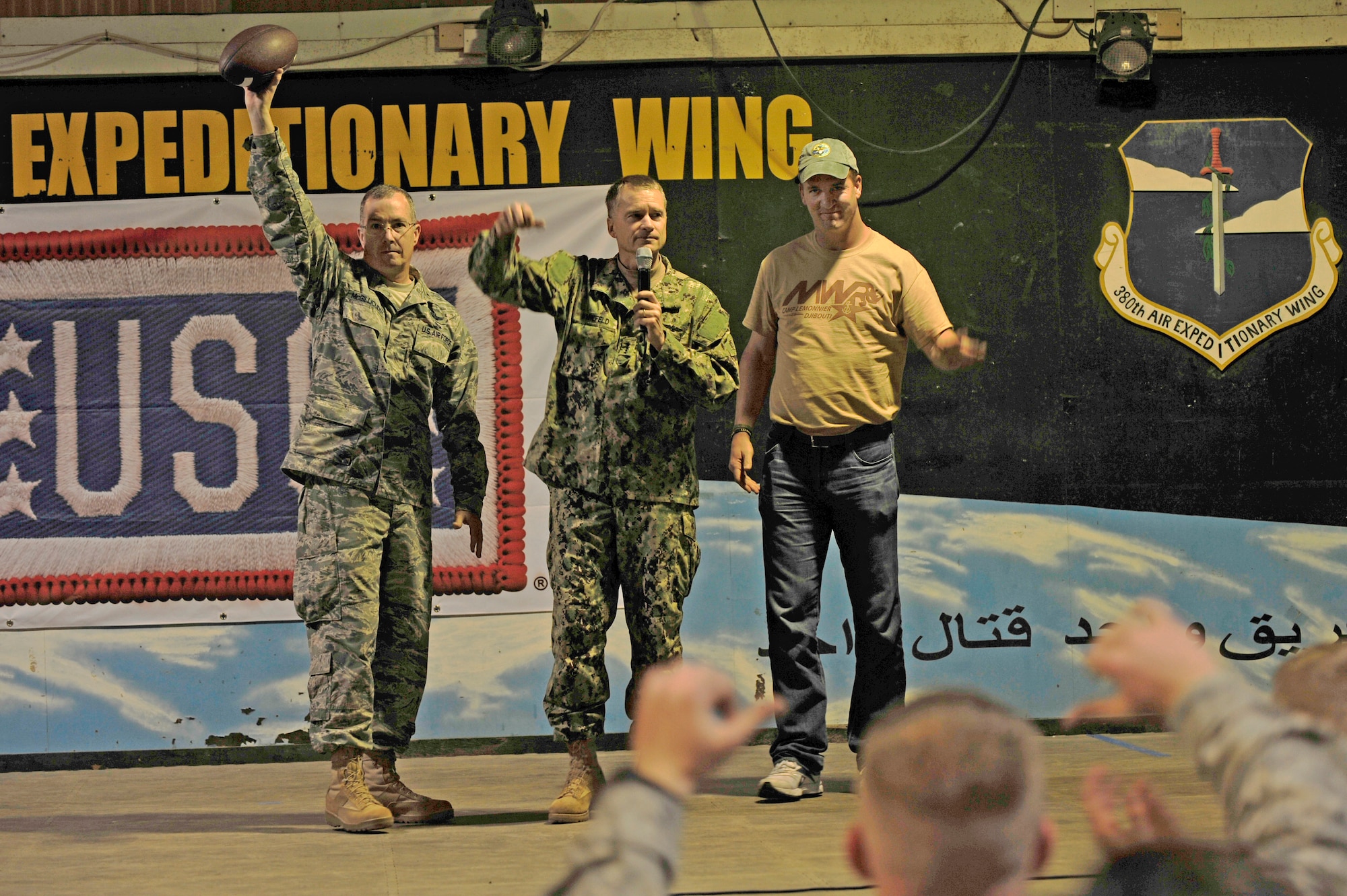 U.S. Air Force Brig. Gen. Paul McGillicuddy, 380th Air Expeditionary Wing commander, and Vice Chairman of the Joint Chiefs of Staff, Navy Adm. James A. Winnefeld Jr. present an autographed football from Denver Broncos Quarterback Peyton Manning to the wing at an undisclosed location in Southwest Asia Feb. 28, 2013. Manning visited the men and women of the 380 AEW to express the country’s gratitude for their service and sacrifice during the Vice Chairman of the Joint Chiefs of Staff Adm. James A. Winnefeld USO tour. (U.S. Air Force photo by Tech. Sgt. Christina M. Styer/Released) 