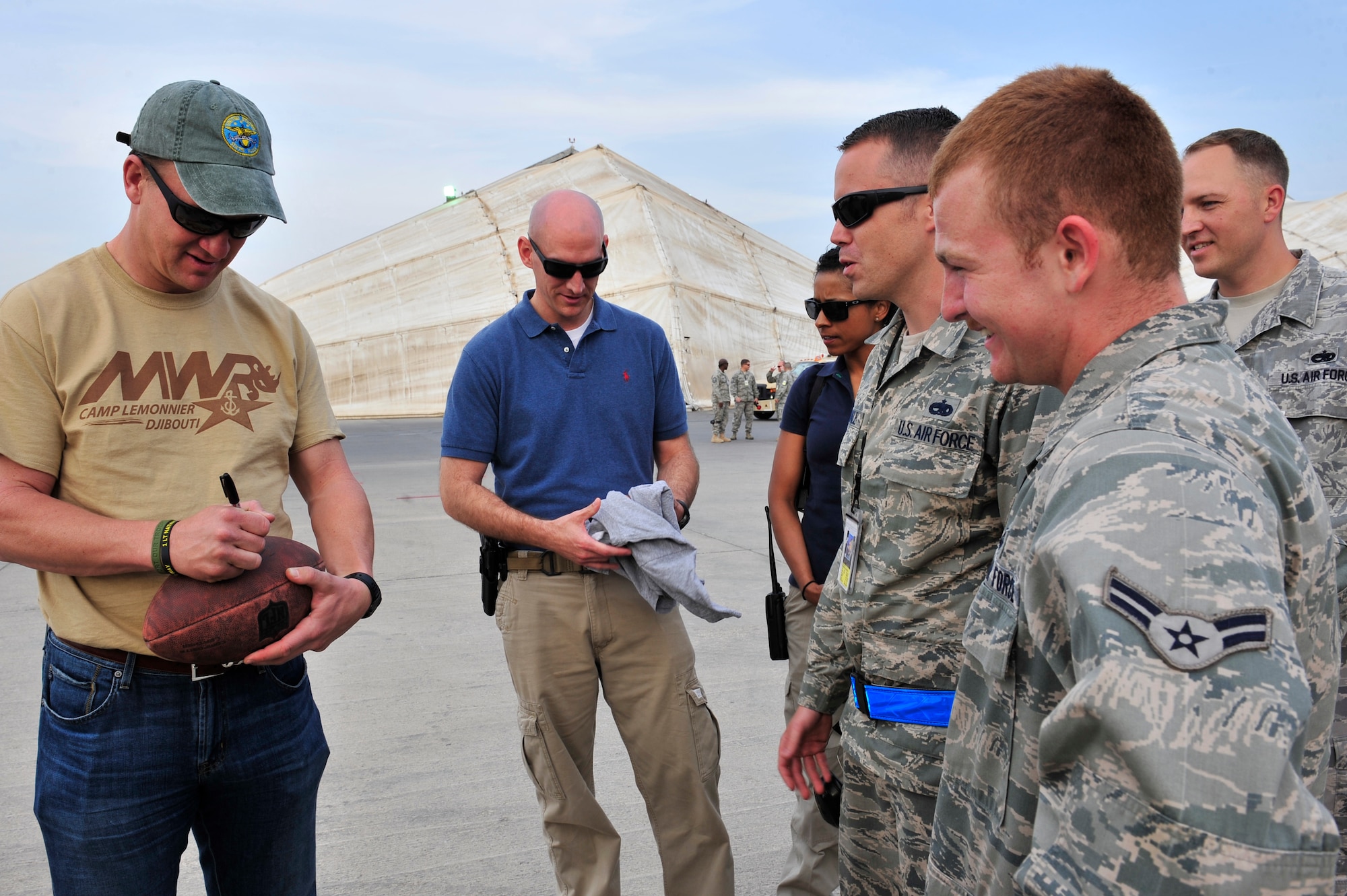Denver Broncos Quarterback Peyton Manning autographs memorabilia for members of the 380th Air Expeditionary Wing at an undisclosed location in Southwest Asia Feb. 28, 2013. Manning visited the men and women of the 380 AEW to express the country’s gratitude for their service and sacrifice during the Vice Chairman of the Joint Chiefs of Staff Adm. James A. Winnefeld USO tour. (U.S. Air Force photo by Tech. Sgt. Christina M. Styer/Released)