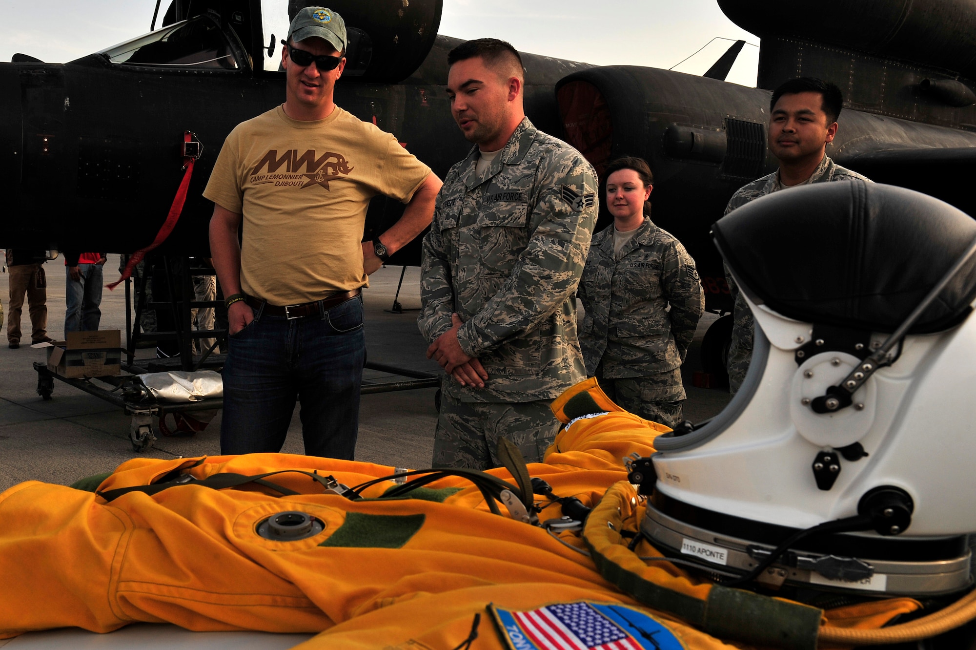 U.S. Air Force Senior Airman Evan Schuelke, 99th Expeditionary Reconnaissance Squadron U-2 launch and recovery technician, explains the full pressure suit U-2 pilots wear during flight to Peyton Manning at an undisclosed location in Southwest Asia Feb. 28, 2013. Manning visited the men and women of the 380th Air Expeditionary Wing to express the country’s gratitude for their service and sacrifice during the Vice Chairman of the Joint Chiefs of Staff Adm. James A. Winnefeld USO tour. (U.S. Air Force photo by Tech. Sgt. Christina M. Styer/Released) 