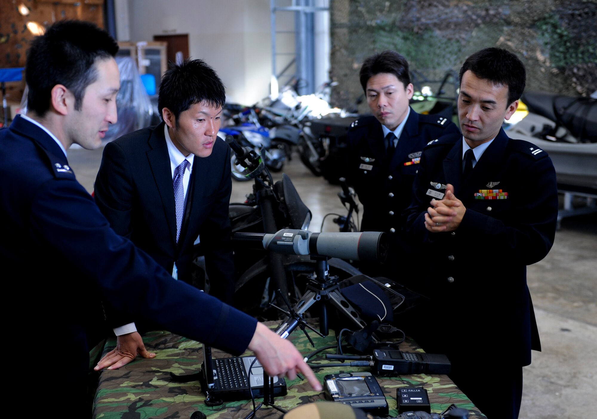 Members of the Japan Air Self Defense Force talk about some of the equipment lying on a table during their visit to the 353rd Special Operations Group on Kadena Air Base, Japan, Feb. 26, 2013. The 353rd SOG is prepared to conduct a variety of high-priority, low-visibility missions. Its mission is air support of joint and allied special operations forces in the Pacific.  (U.S. Air Force photo/Airman 1st Class Justin Veazie)