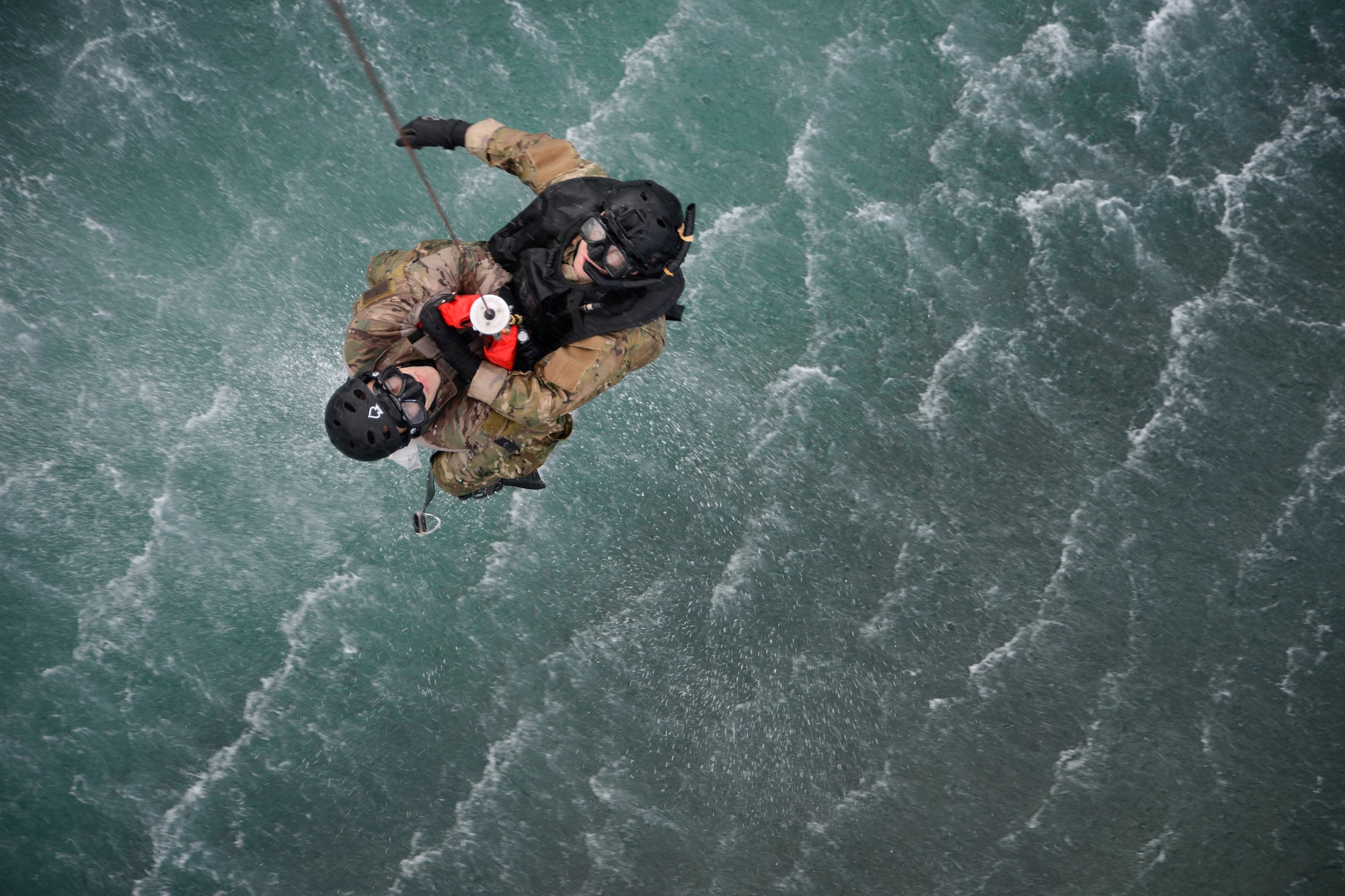 U.S. Air Force Staff Sgt. Nathan Vogel and Senior Airman Zack Asmus, 320th Special Tactics Squadron pararescumen, are hoisted out of the water in performance of a water rescue scenario off the coast of Torii Station, Japan, Feb. 26, 2013. The scenario accompanied bilateral training between U.S. military, Japanese Coast Guard and emergency services, to strengthen communication and processes in the event of an aircraft mishap. (U.S. Air Force photo/Tech. Sgt. Jocelyn L. Rich-Pendracki)