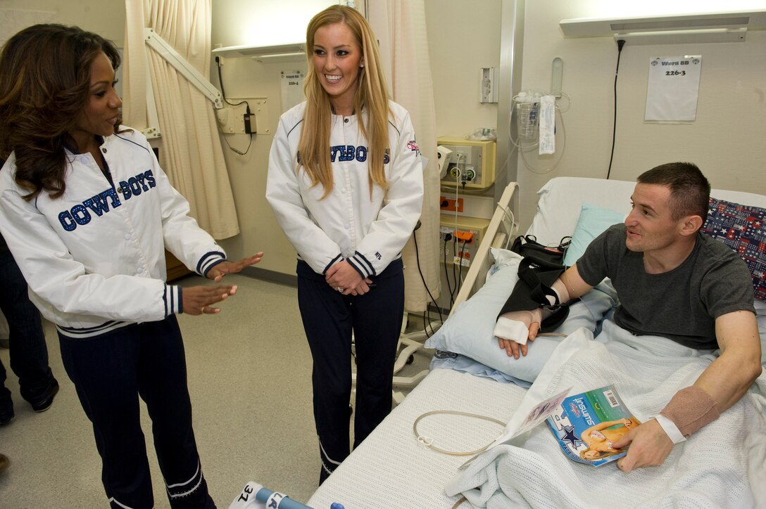 Dallas Cowboys Cheerleaders Jackie Bob, left, and Cassie Trammell visit with Valeri Beriani, a Georgian soldier wounded in Afghanistan, during the USO Spring tour at Landstuhl Regional Medical Center, Germany, March 2, 2013. 