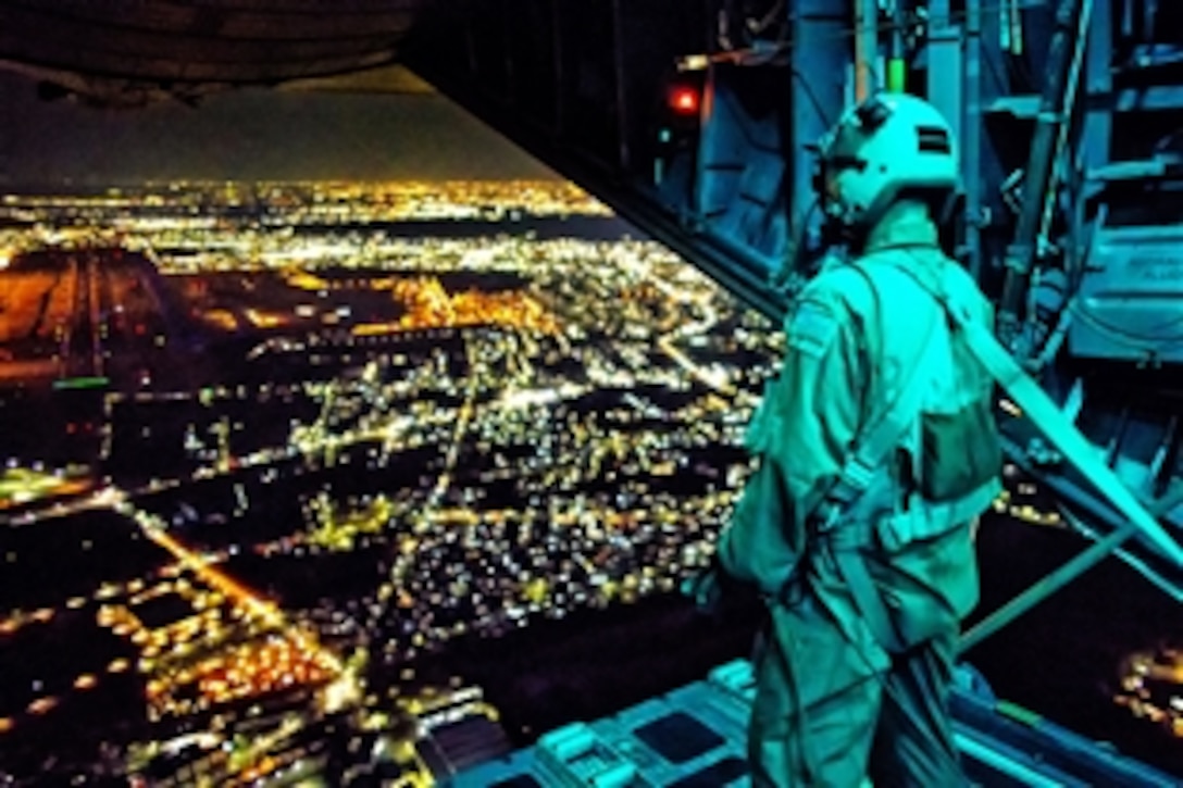 U.S. Air Force Staff Sgt. Nickolas Alarcon observes a drop zone from the rear of a C-130 Hercules aircraft after deploying a light payload above Yokota Air Base, Japan, Feb. 21, 2013. Alarcon, a loadmaster, is assigned to the 36th Airlift Squadron. The C-130 aircrews demonstrated their airlift capabilities during a readiness week.