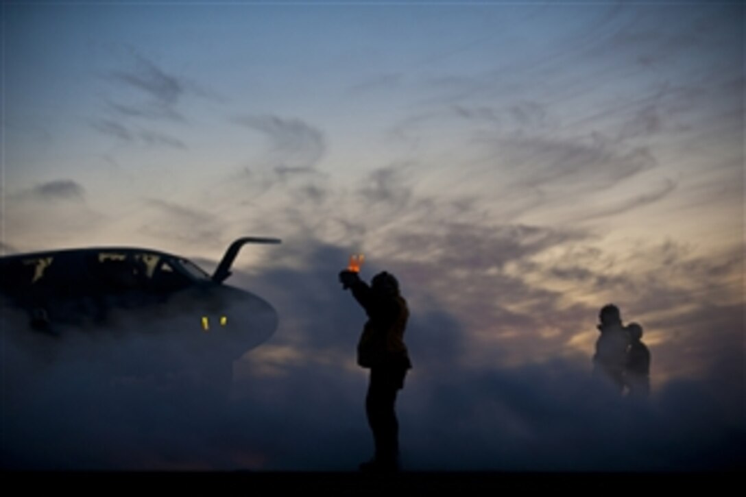 U.S. Navy Petty Officer 2nd Class Leigh Davis uses light wands to direct the pilot of an aircraft on the flight deck of the aircraft carrier USS Carl Vinson (CVN 70) as the ship conducts night flight operations in the Pacific Ocean on Feb. 26, 2013.  Carl Vinson is currently underway conducting fleet replacement squadron carrier qualifications. 