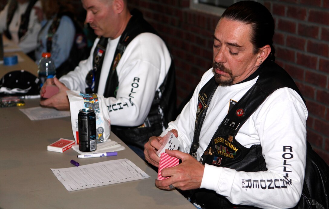 A Rolling Thunder Chapter N.C.-5 volunteer shuffles a deck of cards for a participant to pick one during the 11th Annual Chilly Chili Poker Run starting in Jacksonville Feb. 16. There were four total stops in the poker run, and patrons collected a card at each stop, then they collect their last card upon returning to the starting point, with the best hand winning first place.