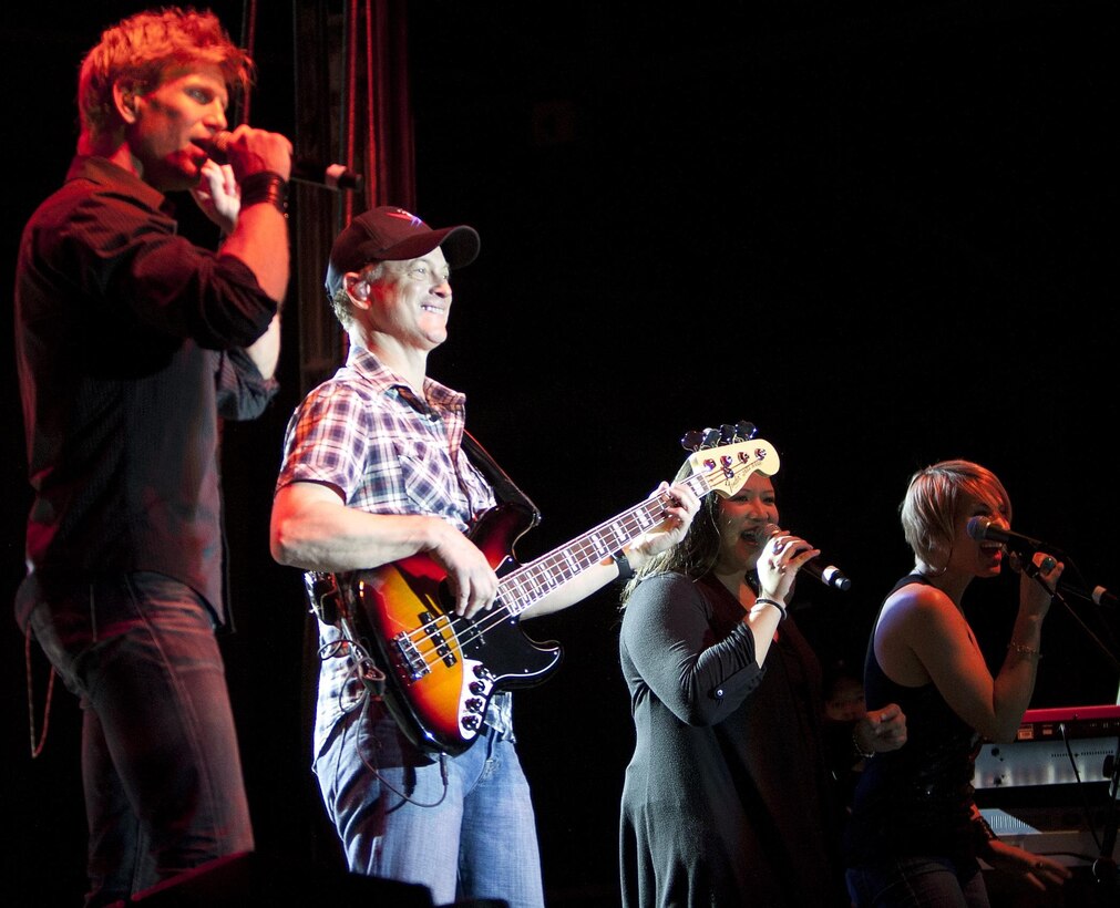 MARINE CORPS BASE HAWAII - Jeff Vezain (left), a vocalist and acoustic guitarist, Gary Sinise, an actor, Academy Award nominee and bass guitarist for the Lt. Dan Band, Mari Anne Jayme, a vocalist, and Molly Callinan, a vocalist, onstage performing during a concert on Marine Corps Base Hawaii, Feb. 22. Sinise, an avid supporter of service members, has toured military installations and performed concerts for troops and their families with the United Service Organizations since 2004. (U.S. Marine Corps photo by Lance Cpl. Suzanna Lapi) 