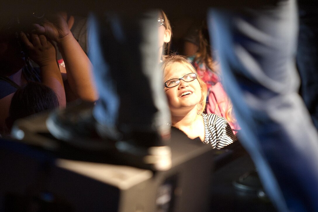 MARINE CORPS BASE HAWAII - An enthusiastic young fan looks on as Gary Sinise, an actor, Academy Award nominee and bass guitarist for the Lt. Dan Band, plays for service members during a concert on Marine Corps Base Hawaii, Feb. 22. Sinise, an avid supporter of service members, has toured military installations and performed concerts for troops and their families with the United Service Organizations since 2004. (U.S. Marine Corps photo by Lance Cpl. Suzanna Lapi) 