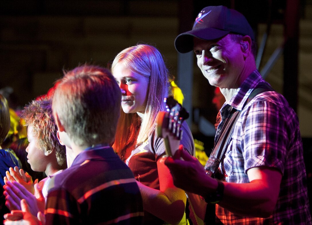 MARINE CORPS BASE HAWAII - Young fans join Gary Sinise, an actor, Academy Award nominee and bass guitarist for the Lt. Dan Band, onstage during a concert on Marine Corps Base Hawaii, Feb. 22. Sinise, an avid supporter of service members, has toured military installations and performed concerts for troops and their families with the United Service Organizations since 2004. (U.S. Marine Corps photo by Lance Cpl. Suzanna Lapi) 