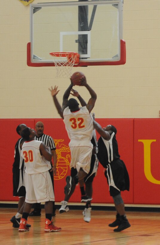 Chris Harris, a guard for the Quantico men’s varsity basketball team, muscles through two Fort Meade Patriot defenders for a layup during a varsity basketball game at Barber Physical Activity Center on March 3. 