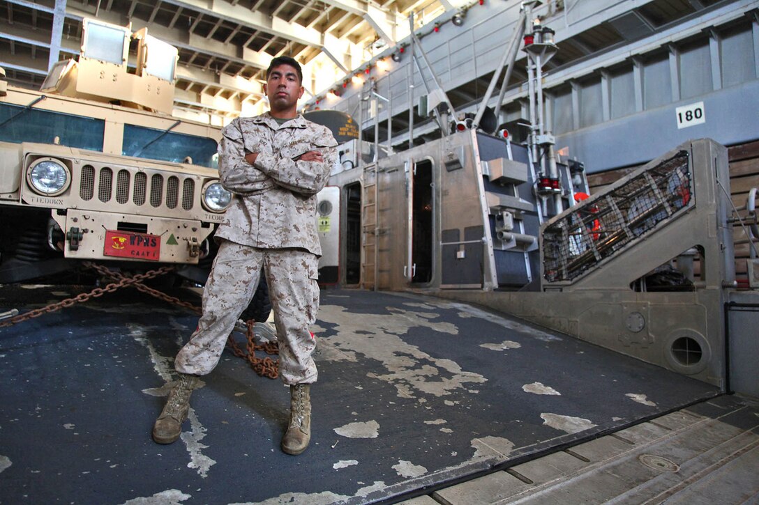 Sergeant Joshua V. Ruiz, landing support specialist, Transportation Support Detachment, Combat Logistics Battalion 15, 15th Marine Expeditionary Unit, poses for a photo in the well-deck of the USS Rushmore, Feb. 19. The 15th MEU is deployed as part of the Peleliu Amphibious Ready Group as a U.S. Central Command theater reserve force, providing support for maritime security operations and theater security cooperation efforts in the U.S. 5th Fleet area of responsibility. (U.S. Marine Corps photo by Cpl. Timothy R. Childers/ Released)