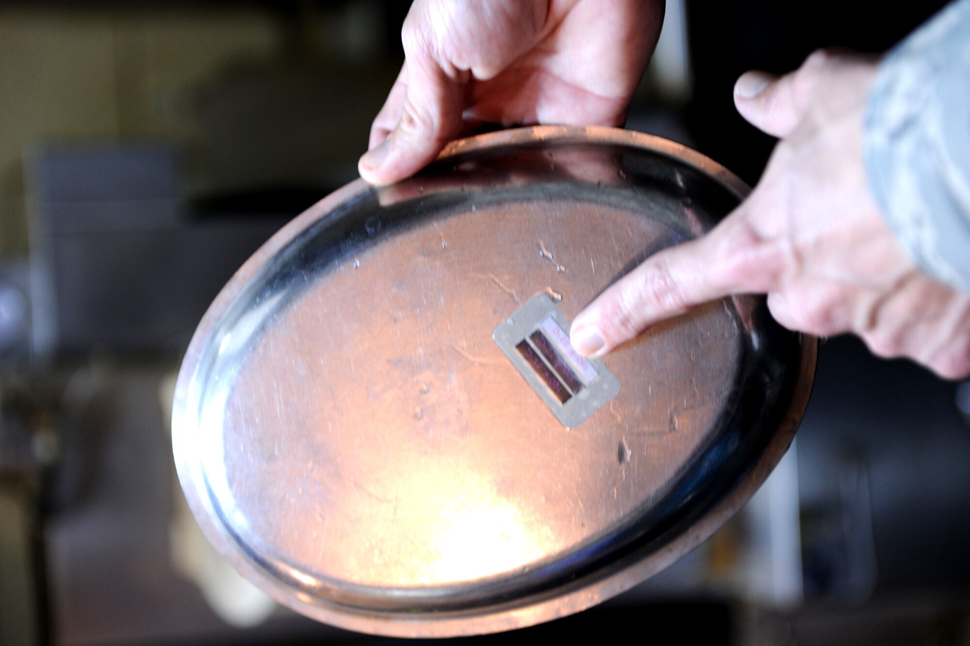 U.S. Air Force Tech. Sgt. Douglas Caldwell, Okuma independent medical technician, checks a thermographic sticker on a dish that he placed in the dishwasher on Okuma, Japan, Feb. 2, 2013. The sticker changes colors when the dishwasher has reached the proper temperature to kill bacteria. (U.S. Air Force photo/Airman 1st Class Brooke P. Doyle)