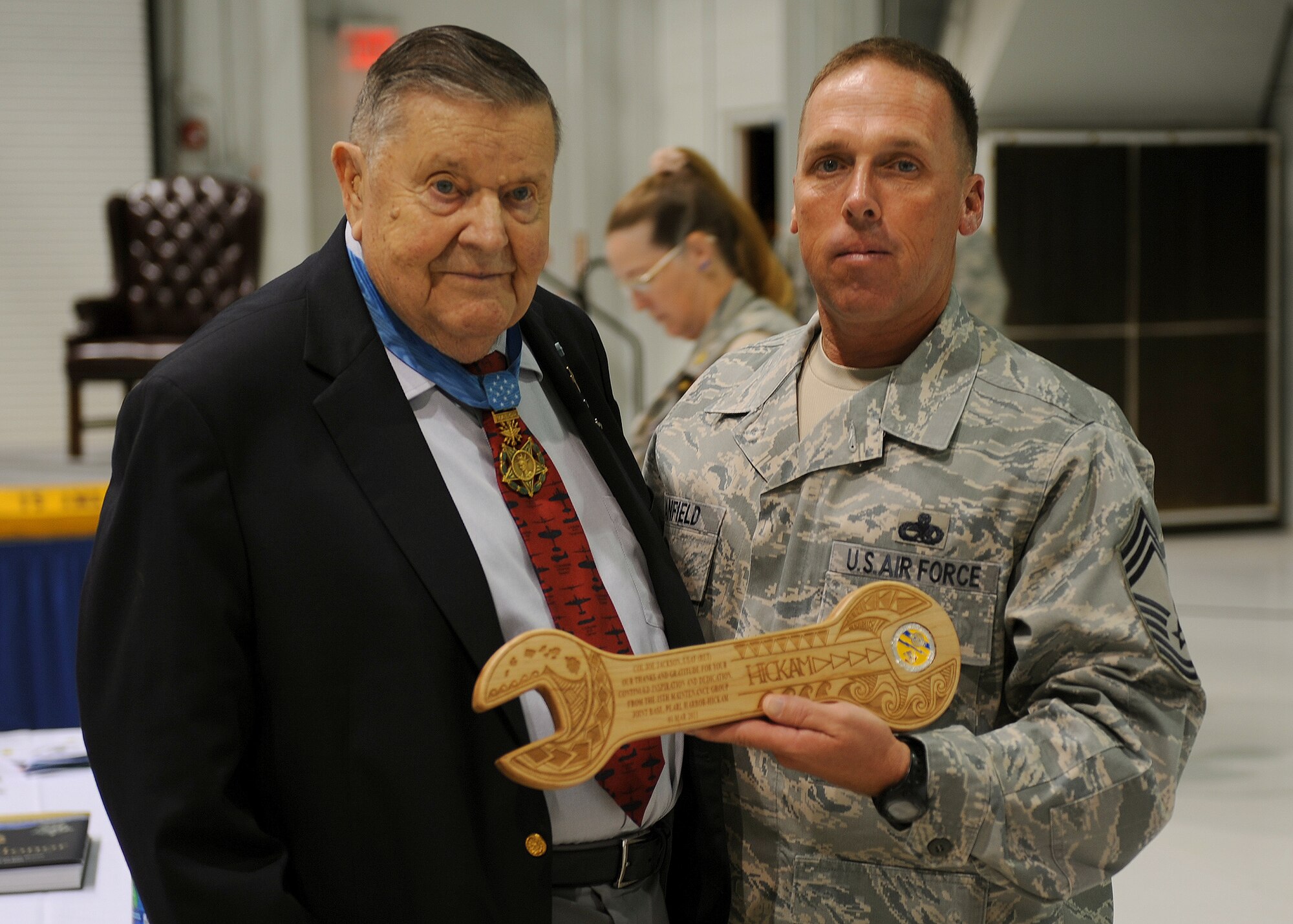 Chief Master Sgt. William H. Canfield, 15th Maintenance Group superintendent, presents a plaque to U.S. Air Force Medal of Honor recipient Col. (retired) Joe Jackson during the 15th Maintenance Group’s Knucklebuster Banquet at Hangar 19, Joint Base Pearl Harbor-Hickam, Hawaii, March 1, 2013. Jackson served as the motivational guest speaker for the event and shared details of his 33 year career as a maintainer and pilot. (U.S. Air Force photo/Staff Sgt. Terri Barriere)