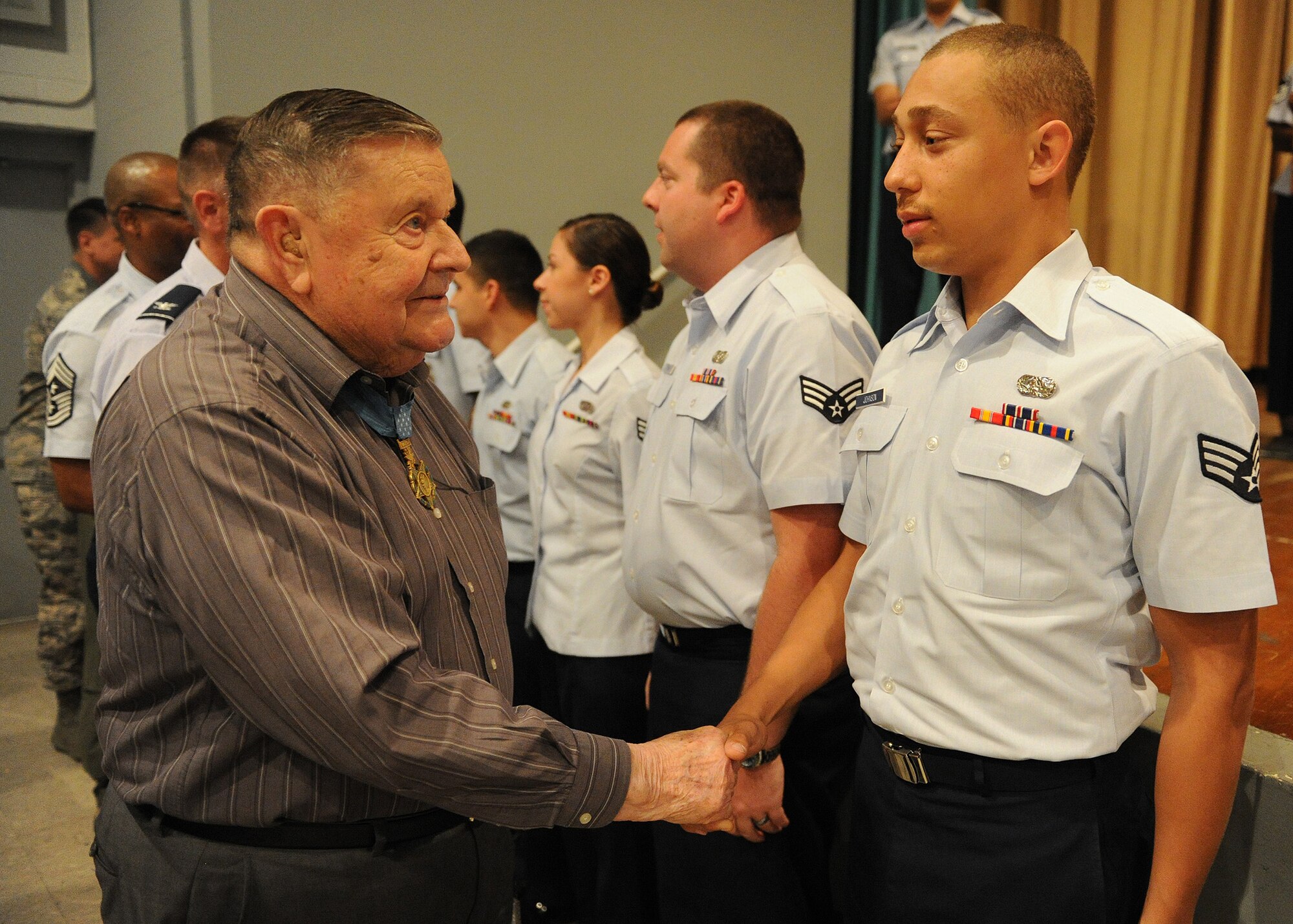 U.S. Air Force Medal of Honor recipient Col. (retired) Joe Jackson congratulates newly promoted Senior Airman Travis L. Johnson, 747th Communication Squadron, information assurance technician, at the 15th Wing’s promotion ceremony at the Memorial Theater, Joint Base Pearl Harbor-Hickam, Hawaii, Feb. 28, 2013. Johnson was one of several airmen who got the rare opportunity to meet patriotic figure. (U.S. Air Force photo/Tech. Sgt. Jerome S. Tayborn)