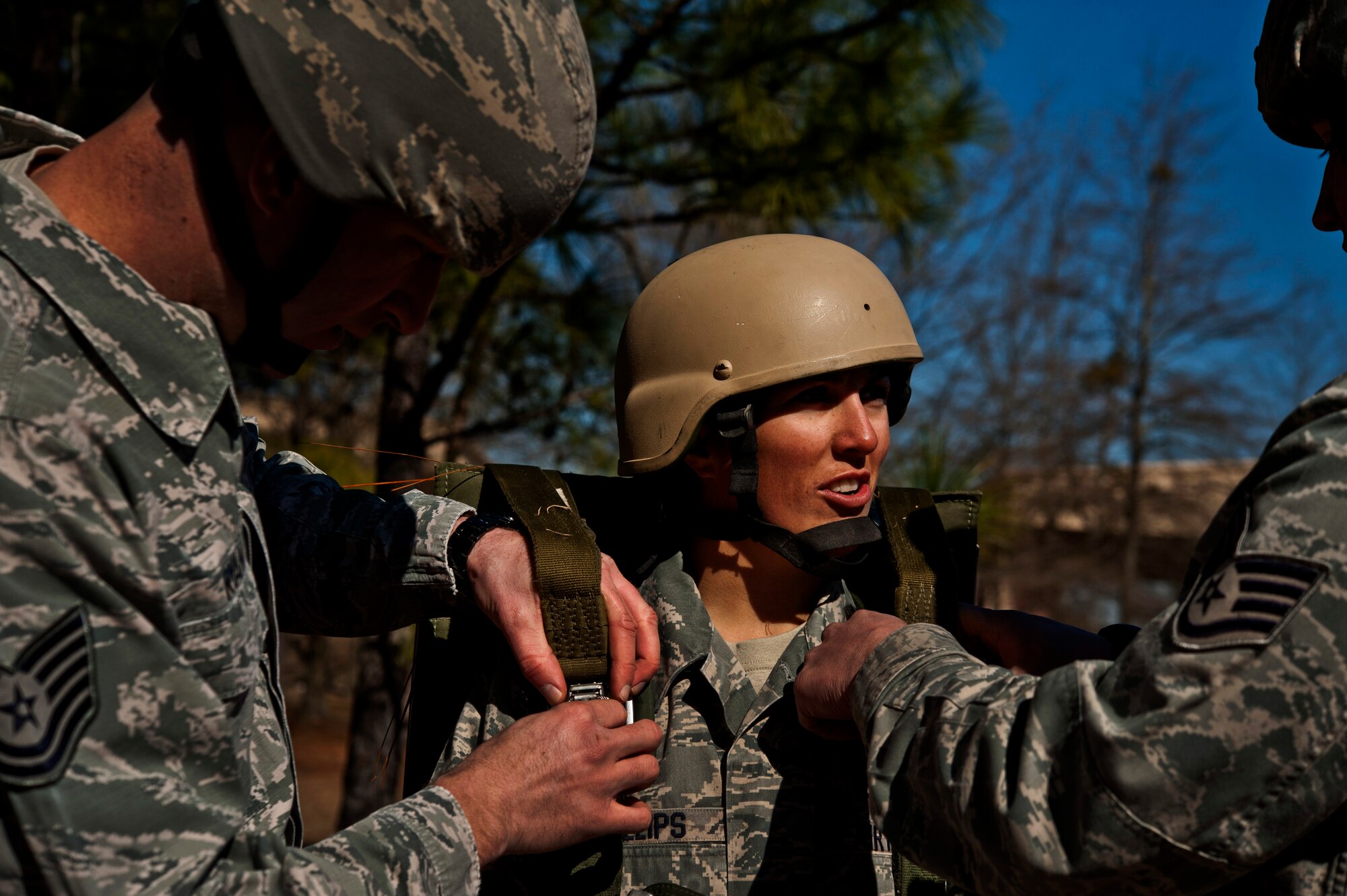 U.S. Air Force Staff Sgt. Christine Phillips, 820th Rapid Engineer Deployable Heavy Operational Repair Squadron Engineers Airborne from Nellis Air Force Base, Nev., has her parachute harness tightened during a T-11 parachute training class Feb. 21, 2013, at Fort Bragg, N.C. The T-11 parachute is a bigger parachute than the 820th RED HORSE Airmen are used to using. (U.S. Air Force photo by Senior Airman Daniel Hughes)