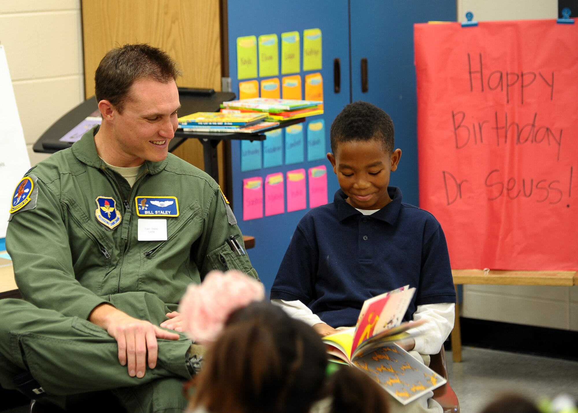 Capt. William Staley, 14th Student Squadron, reads "The Foot Book" by Dr. Seuss to a student at West Lowndes Elementary School March 1 in Columbus, Miss. Students spent the morning listening to stories by Dr. Seuss and eating green eggs and ham in celebration of Seuss's birthday. (U.S. Air Force Photo by Airman 1st Class Stephanie Englar)