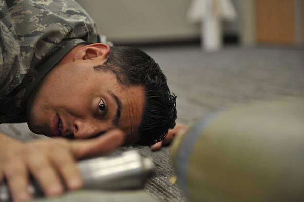WHITEMAN AIR FORCE BASE, Mo. -- Airman 1st Class Fernando Aguilera, 509th Civil Engineer Squadron Explosive Ordnance Disposal team member, sets a Mark-Two on a Mark-82 bomb with fuse, Feb. 27. This training helps EOD technicians learn proper placement of the Mark-Two, which is used for rendering safe fuses. (U.S. Air Force photo/ Airman 1st Class Keenan Berry) (Released) 
