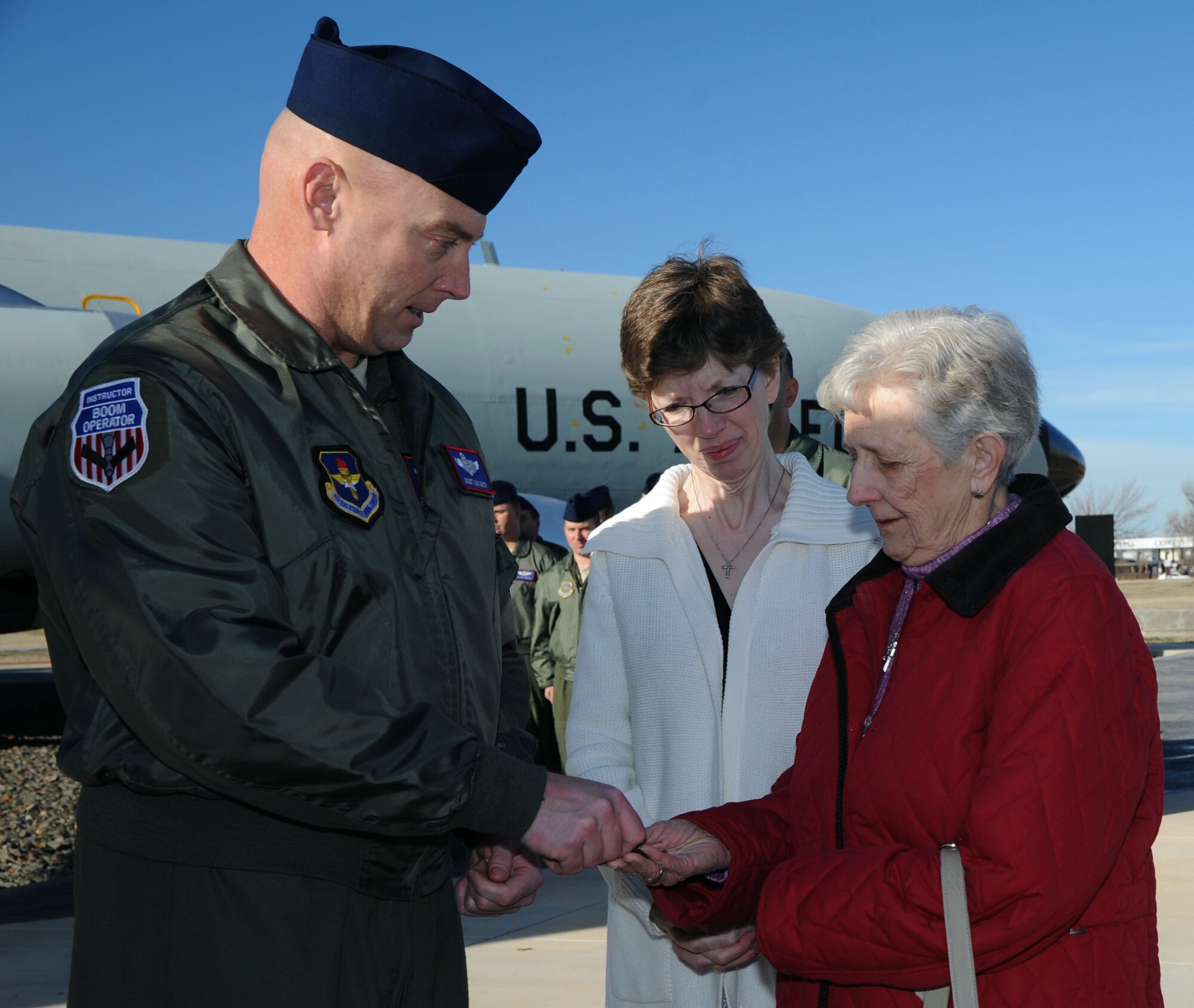 ALTUS AIR FORCE BASE, Okla. – Chief Master Sgt. Daniel Smith, 54th Air Refueling Squadron superintendent, presents Luella Klaverkamp, mother of late KC-135 Stratotanker boom operator, Airman 1st Class Bruce Klaverkamp, a boom operator coin with Bruce’s boom number on it at Wings of Freedom Park, March 3, 2013. Bruce died in a plane crash, March 13, 1972, during a routine training mission at Carswell AFB, Texas. Klaverkamp and her daughter and son-in-law, Lisa and Jeff Pollreis, made an 18-hour drive from Clear Water, Minnesota to Altus AFB to visit the Boom Memorial where Bruce’s name is etched in stone, a testament to his service. (U.S. Air Force photo by Airman 1st Class Klynne Pearl Serrano / Released)