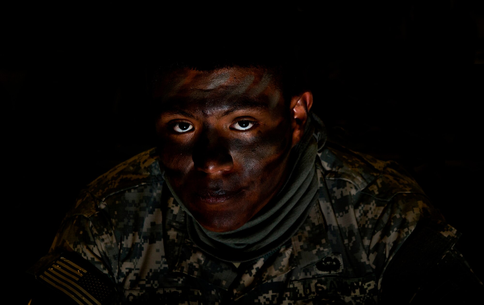 U.S. Army Private 1st Class Francisco Garnica, 161st Engineer Support Company combat airborne, waits in full face paint to participate in a Joint Access Operation Exercise jump mission Feb. 23, 2013, at Fort Bragg, N.C. Face paint helps break up skin color, which helps for tactical exercises or night jumps. (U.S. Air Force photo by Senior Airman Daniel Hughes)
