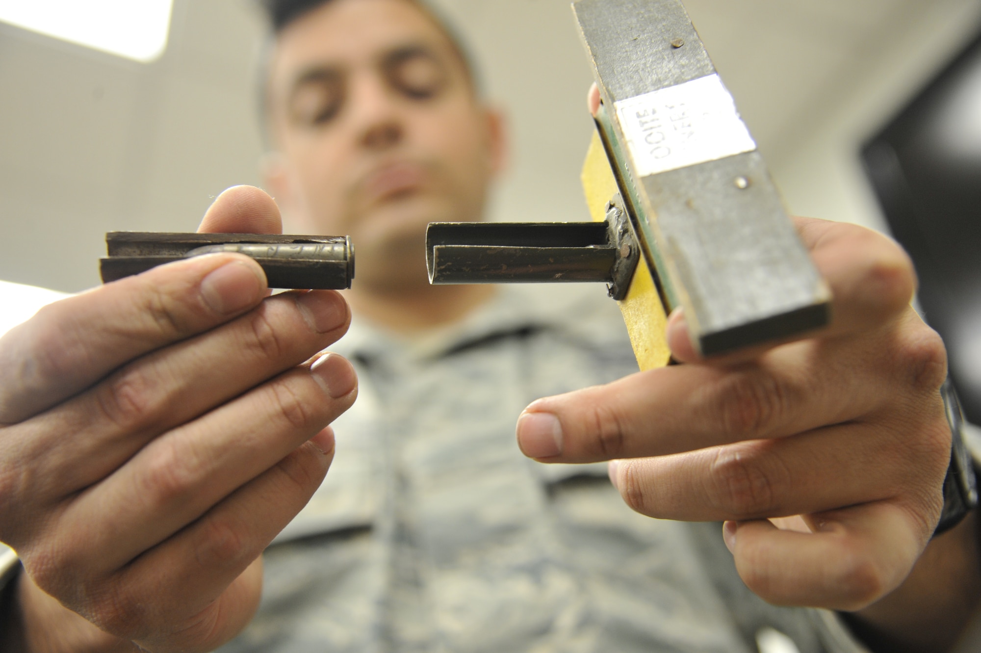 WHITEMAN AIR FORCE BASE, Mo. -- Airman 1st Class Fernando Aguilera, 509th Civil Engineer Squadron Explosive Ordinance Disposal team member, examines at a land mine, Feb. 27. This mine is designed as a defensive weapon to explode when stepped on. (U.S. Air Force photo/Airman 1st Class Keenan Berry) (Released)
