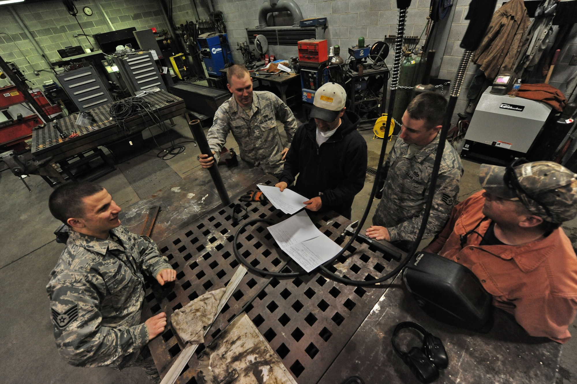 WHITEMAN AIR FORCE BASE, Mo. -- Members from the 509th Civil Engineer Squadron structures flight discuss procedures for snow plow repair, Feb. 27. The flight constructs, remodels, repairs and maintains 861 base facilities totaling over 4.8 million square feet. (U.S. Air Force photo/Staff Sgt. Nick Wilson) (Released)