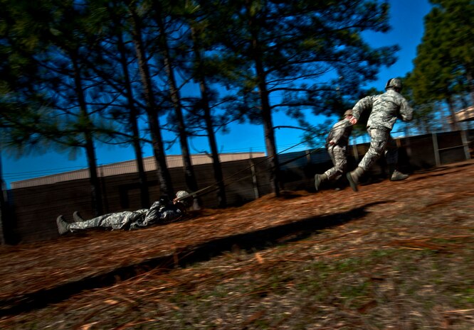 U.S. Air Force Staff Sgt. Kyle St. Vincent, Staff Sgt. Nicholas Urban, Staff Sgt. Andrew Klodt, 820th Rapid Engineer Deployable Heavy Operational Repair Squadron Engineers airborne flight, simulate being dragged after landing during a T-11 parachute training class Feb. 21, 2013, at Fort Bragg, N.C. This training course was to give RED HORSE airborne Airmen a refresher course on the T-11 model parachute before their jump later in the week. (U.S. Air Force photo by Senior Airman Daniel Hughes)