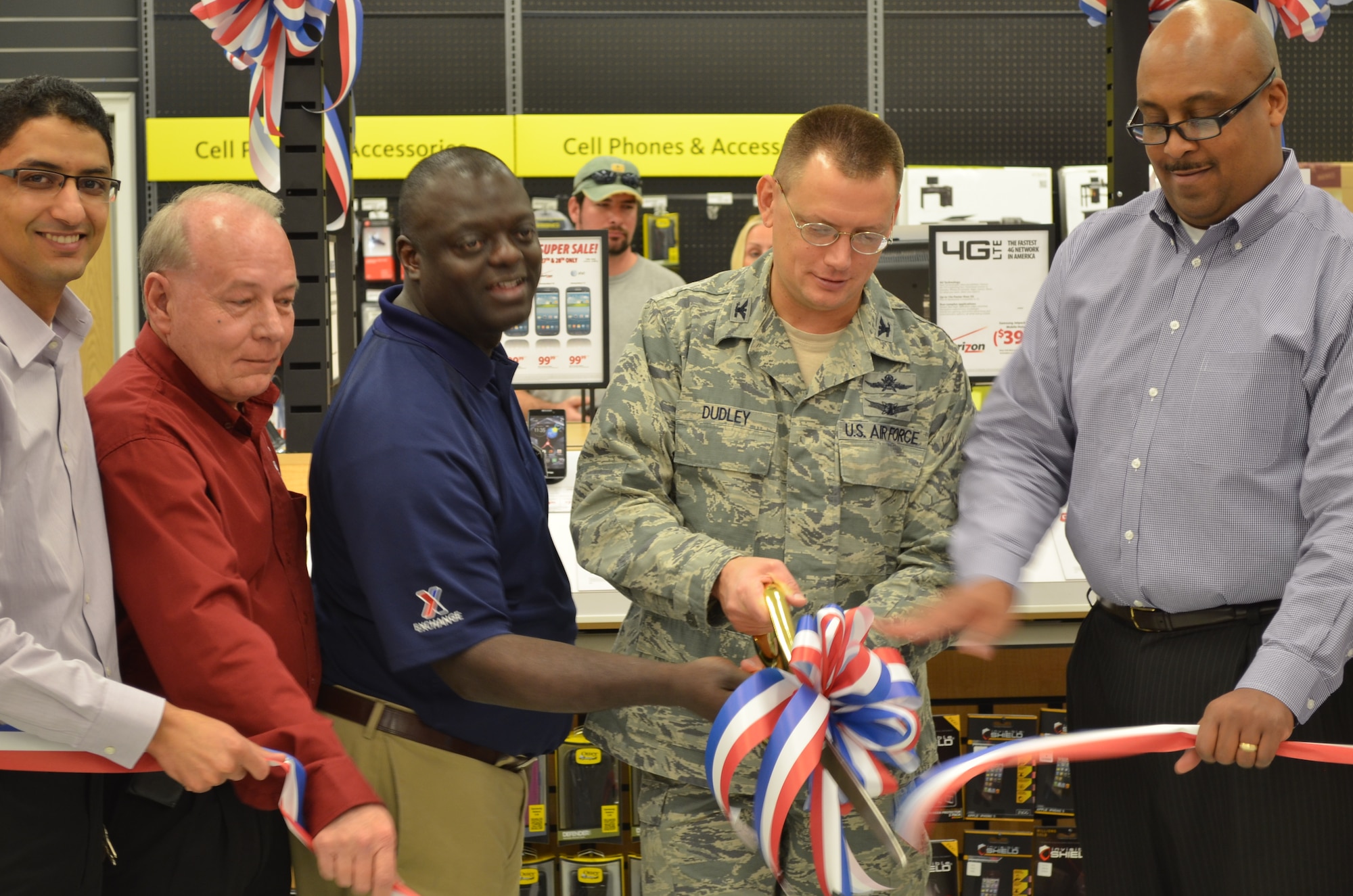 HURLBURT FIELD, Fla. – U.S. Air Force Col. Douglas Dudley, commander of 1st Special Operations Mission Support Group (Center), cuts the ribbon at Hurlburt’s Base Exchange to celebrate the opening of the Exchange Mobile Kiosk at Hurlburt Field, Fla., Feb. 28, 2013. Attending the ceremony, from left to right, are Mohammed Aouam - exchange telecom specialist, Steve Friend - Eglin/Hurlburt Services business manager, Tim Hall - Hurlburt store manager, Col. Dudley and Todd Chinn – the wireless advocates regional manager.(Coutersy Photo)