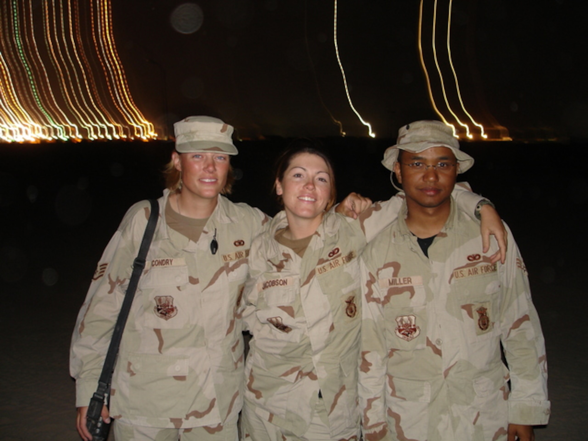 Airman 1st Class Elizabeth Jacobson (middle), smiles with two of her fellow Airmen, during her deployment to Iraq in 2005. Jacobson was killed on Sept. 28, 2008, when a roadside bomb detonated near her vehicle on a convoy delivering supplied to Camp Bucca, Iraq. Jacobson was a security forces member with the 17th Security Forces Squadron at Goodfellow Air Force Base, Texas. (Courtesy photo)