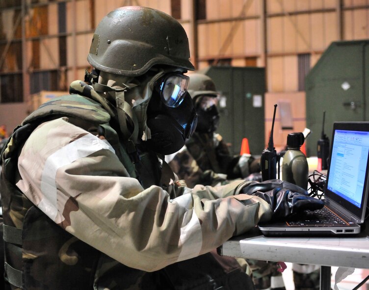 Senior Airman Michael Salcedo, 436th Maintenance Operations Squadron, works on a computer following a simulated attack Mar. 4, 2013, at Dover Air Force Base, Del. Part of the Operational Readiness Exercise evaluates an Airmen’s ability to do their job while wearing chemical warfare protective gear. (U.S. Air Force photo/Tech. Sgt. Chuck Walker