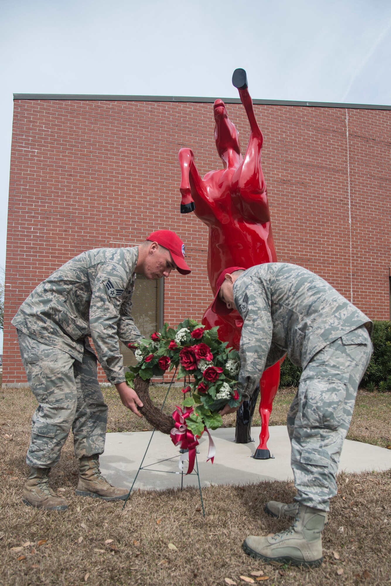 Airman 1st Class Jonathan Liebherr, 560th Rapid Engineer Deployable, Heavy Operational Repair Squadron airfields apprentice, and Senior Airman Juan Moreno, 560th RED HORSE structures apprentice, lay a wreath by "Charging Charlie" during the memorial ceremony in honor of Brig. Gen. Tom Meredith Feb. 27, 2013, at Joint Base Charleston – Air Base, S.C. Meredith founded the RED HORSE unit, and was the first commander of the active-duty RED HORSE unit when it was established to train RED HORSE Airmen for service in Vietnam in 1967.