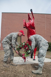 Airman 1st Class Jonathan Liebherr, 560th Rapid Engineer Deployable, Heavy Operational Repair Squadron airfields apprentice, and Senior Airman Juan Moreno, 560th RED HORSE structures apprentice, lay a wreath by "Charging Charlie" during the memorial ceremony in honor of Brig. Gen. Tom Meredith Feb. 27, 2013, at Joint Base Charleston – Air Base, S.C. Meredith founded the RED HORSE unit, and was the first commander of the active-duty RED HORSE unit when it was established to train RED HORSE Airmen for service in Vietnam in 1967.