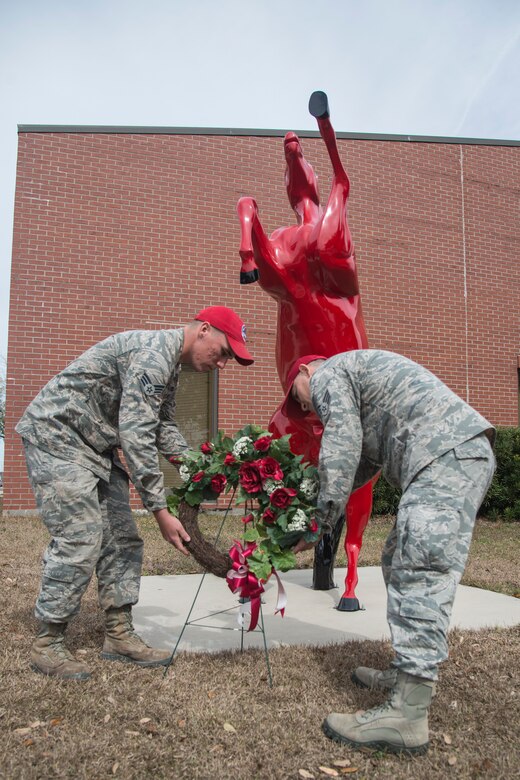 Airman 1st Class Jonathan Liebherr, 560th Rapid Engineer Deployable, Heavy Operational Repair Squadron airfields apprentice, and Senior Airman Juan Moreno, 560th RED HORSE structures apprentice, lay a wreath by "Charging Charlie" during the memorial ceremony in honor of Brig. Gen. Tom Meredith Feb. 27, 2013, at Joint Base Charleston – Air Base, S.C. Meredith founded the RED HORSE unit, and was the first commander of the active-duty RED HORSE unit when it was established to train RED HORSE Airmen for service in Vietnam in 1967.