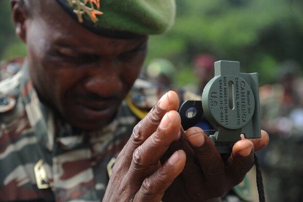 A Cameroon defense forces member uses a compass to determine proper aircraft heading and aerial delivery drop zone marker placement prior to a Cameroon air force C-130 low-cost low-altitude bundle air drop during Central Accord 2013, at the Cameroon defense forces engineer base, Douala, Cameroon, February 27, 2013. Central Accord 2013 is a joint exercise in which U.S., Cameroon and neighboring Central African militaries partner to promote regional cooperation while and increasing aerial resupply and medical readiness capacity. (Photo by Master Sgt. MSgt Stan Parker)