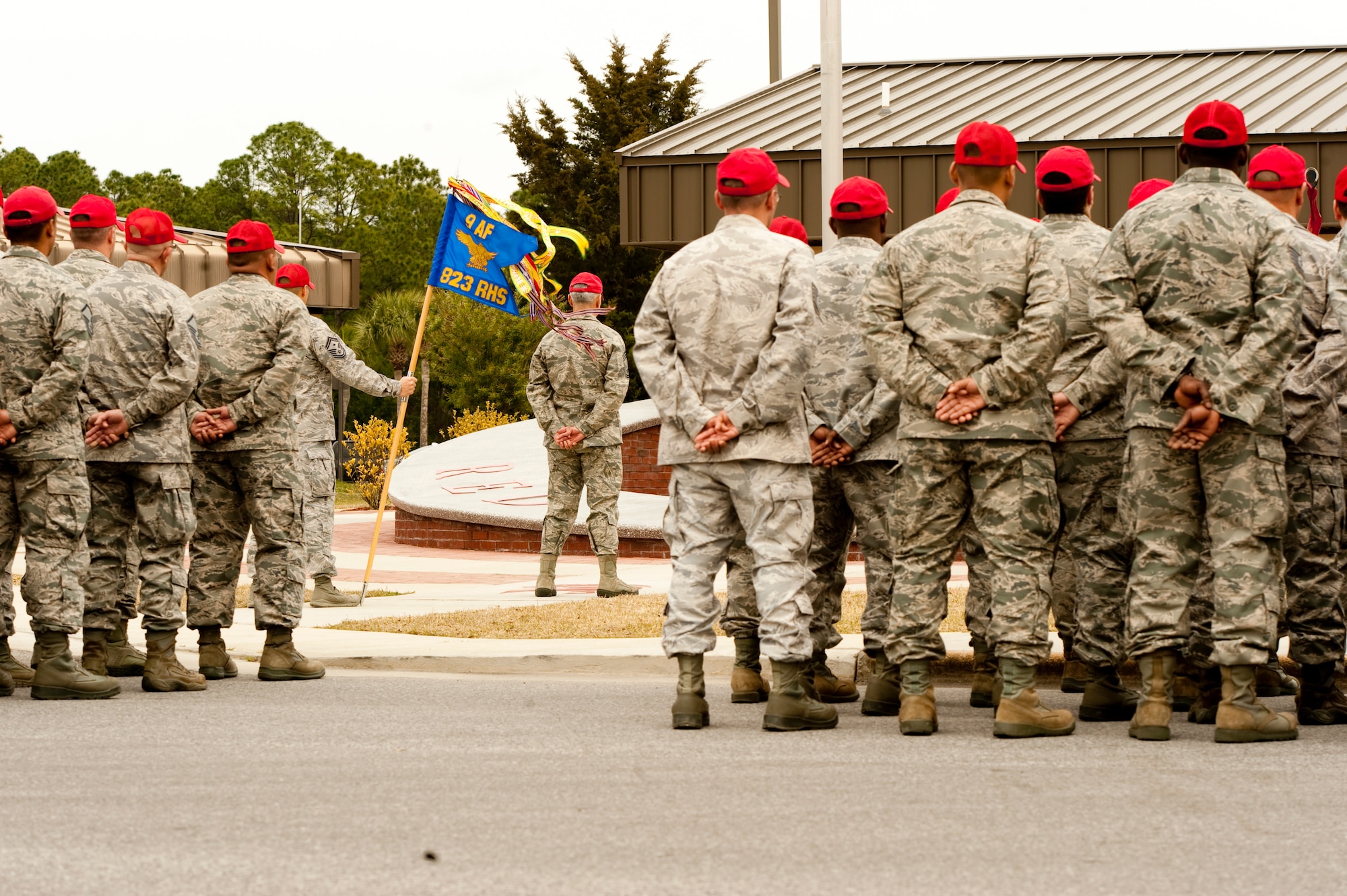 Airmen of 823rd RED HORSE Squadron stand at parade rest and await Lt. Col. Ann Birchard, commander of 823rd RHS, to present the significance of the gathering.  As tribute to retired Brig. Gen. William Thomas Meredith’s recent passing, the 823rd RHS took a moment of silence and flew their squadron flag at half-staff.  (U.S. Air Force photo by Airman 1st Class Benjamin D. Kim)