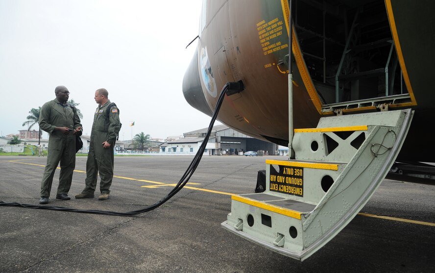 U.S. Air Force Capt. Mark Lyerly, Air Mobility Command Test and Evaluation Squadron C-130 navigator instructor, Joint Base McGuire-Dix-Lakehurst, N.J., chats with Cameroon Air Force Capt. Mindie Yannick, a C-130 navigator, before boarding a CAF C-130, during Central Accord 2013, at Douala Air Force Base, Douala, Cameroon, February 23, 2013. Lyerly of Niceville, Fla., is participating in Central Accord 2013, a joint exercise in which U.S., Cameroon and neighboring Central African militaries partner to promote regional cooperation while increasing aerial resupply and medical readiness capacity. (U.S. Air Force photo/Master Sgt. Stan Parker)
