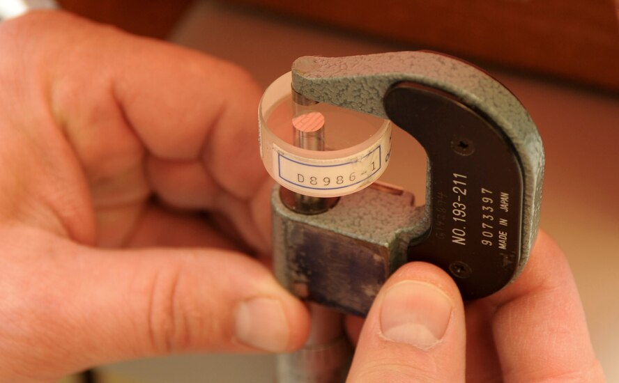 Gregory Larson, 28th Maintenance Squadron precision measurement equipment lab quality assurance inspector, demonstrates how the flatness of a measuring surface is verified using a precision optical flat and monochromatic light source at Ellsworth Air Force Base, S.D., Feb. 20, 2013. Measurements must be accurate to ensure optimal performance and prevent safety hazards. (U.S. Air Force photo by Airman 1st Class Anania Tekurio/Released)