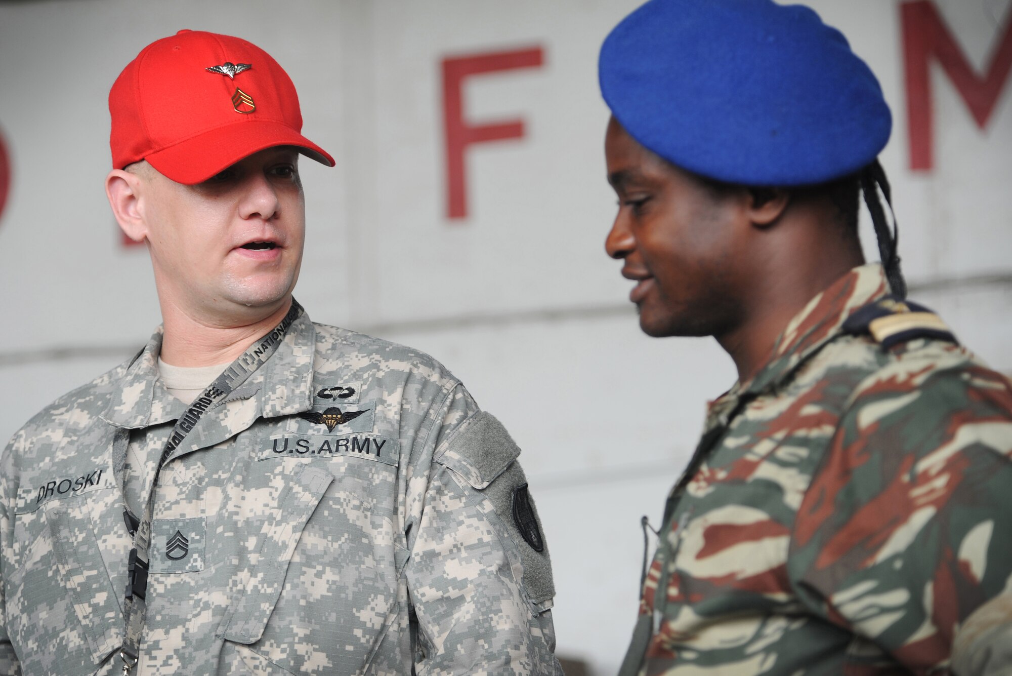 DOUALA, CAMEROON – U.S. Army Staff Sgt. Jacob Droski, a parachute rigger assigned to the 5th Quartermaster Battalion Detachment, Kaiserslautern, Germany, shares his experience building low-cost low-altitude air drop bundles with an African partner nation exercise participant during Central Accord 2013, at Douala Air Force Base, Douala, Cameroon, February 21, 2013. Droski is participating in Central Accord 2013, a joint exercise in which U.S., Cameroon and neighboring Central African militaries partner to promote regional cooperation while and increasing aerial resupply and medical readiness capacity. (Photo by Master Sgt. MSgt Stan Parker, 621st CRW Public Affairs)