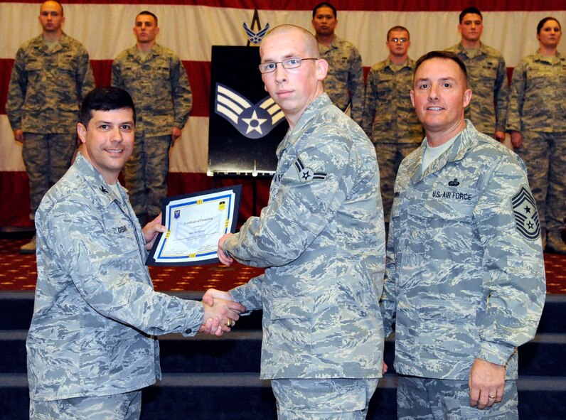 Airman 1st Class Eric Young, 2nd Operations Squadron, receives a certificate of promotion to Senior Airman from Col. Andrew Gebara, 2nd Bomb Wing commander, during the March Wing Promotion Ceremony on Barksdale Air Force Base, La., March 1. (U.S. Air Force photo/Airman 1st Class Andrew Moua)