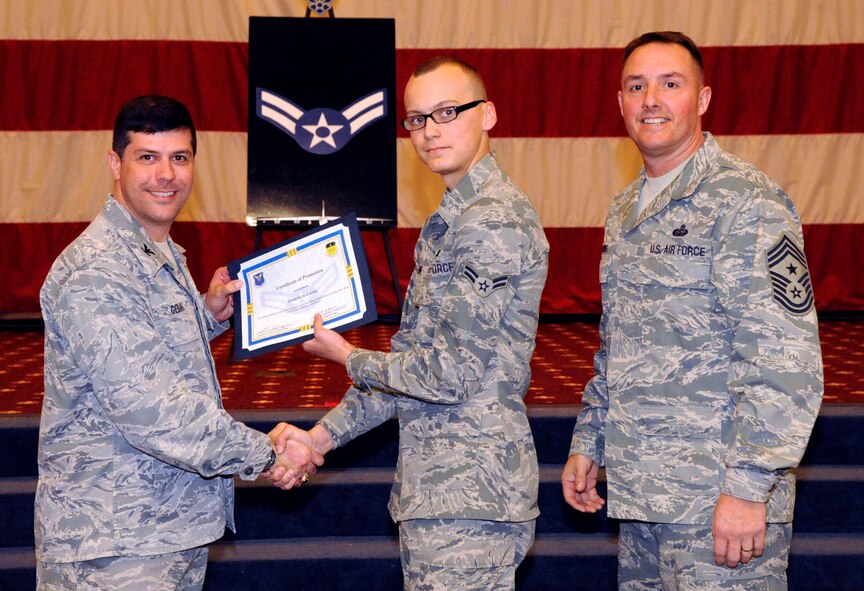 Airman Joseph Caine, 2nd Aircraft Maintenance Squadron, receives a certificate of promotion to Airman 1st Class from Col. Andrew Gebara, 2nd Bomb Wing commander, during the March Wing Promotion Ceremony on Barksdale Air Force Base, La., March 1. (U.S. Air Force photo/Airman 1st Class Andrew Moua)