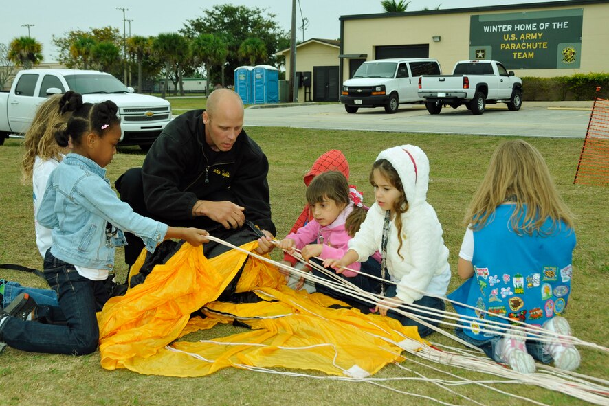 Army Golden Knight Sgt. 1st Class Teigh Statler shows Girl Scouts from Troop 408, Christ Fellowship Academy from Palmetto Bay, Fla., how to back a parashute during a tour the scouts took of Homestead Air Reserve Base, Fla. March 1. (U.S. Air Force photo/Tim Norton)
