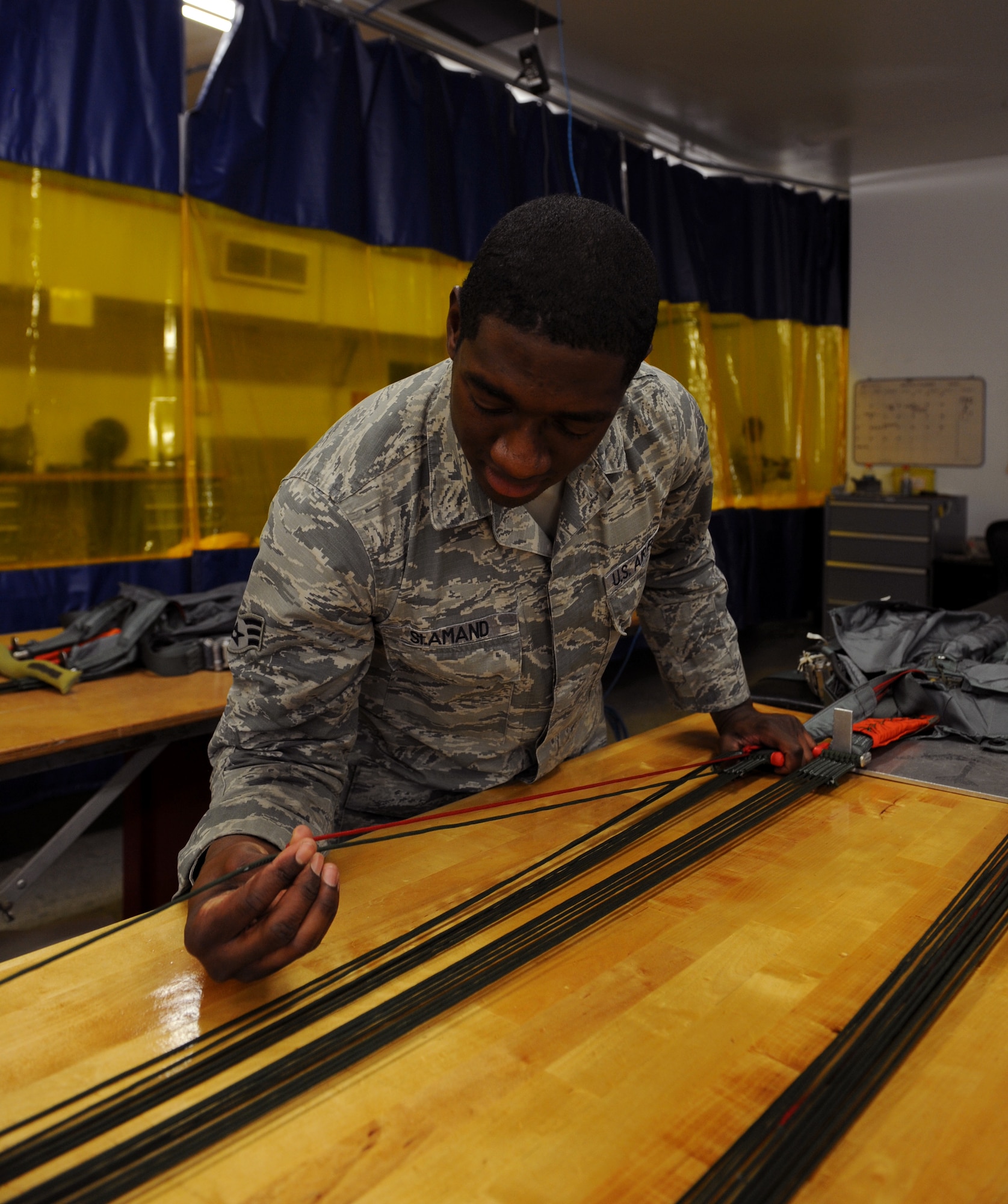 Senior Airman Ernest St. Amand, 2nd Operations Support Squadron Aircrew Flight Equipment Parachute Shop, prepares to measure a four-line jettison on Barksdale Air Force Base, La., March 5. If an aircrew member deploys their chute, the four-line jettison is used to steer the individual to safety. (U.S. Air Force photo/Airman 1st Class Benjamin Gonsier) 
