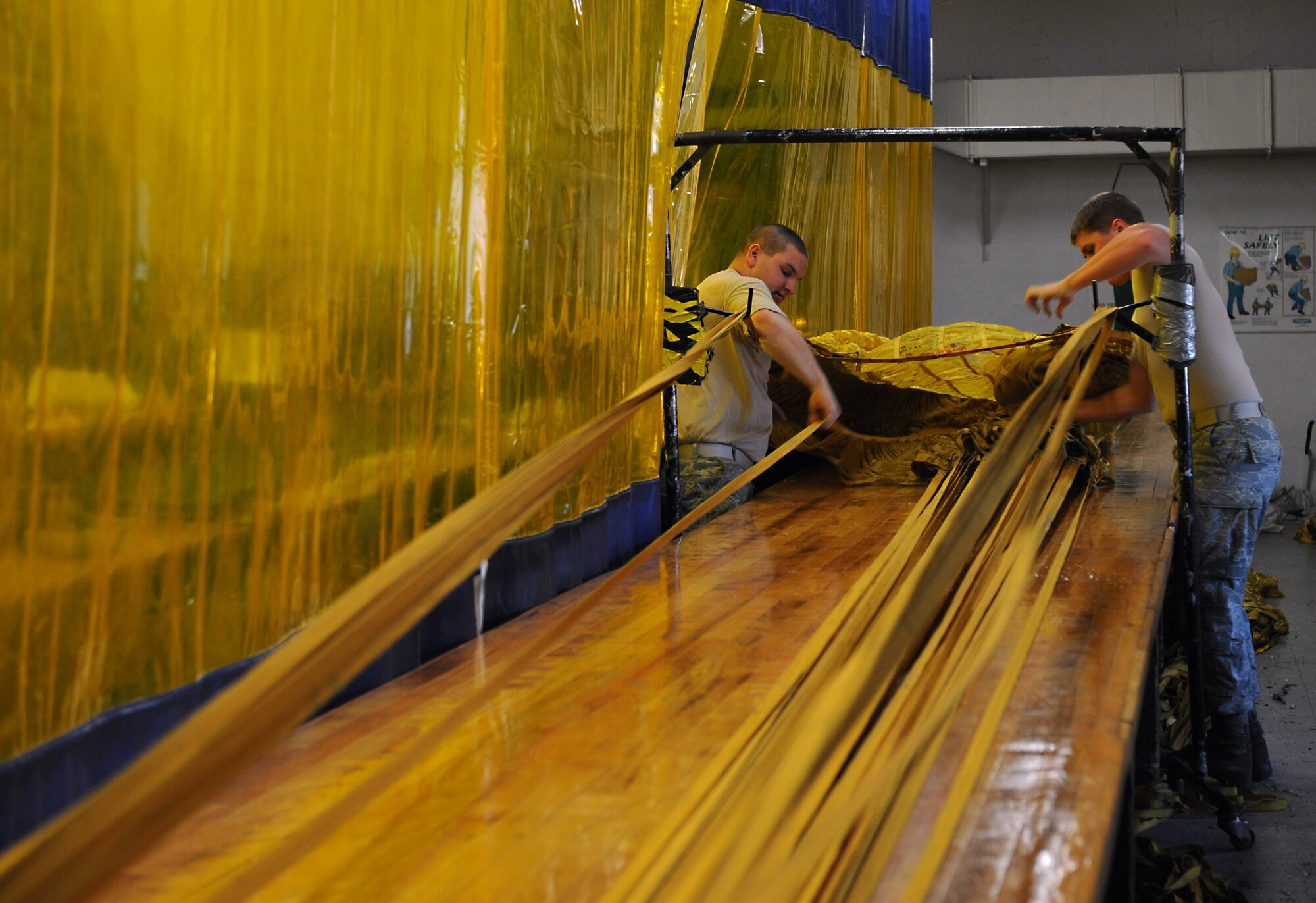 Senior Airman Kelly Adkins and Airman 1st Class Tyler Shepherd, 2nd Operations Support Squadron Aircrew Flight Equipment Parachute Shop, separates drag chute suspension lines on Barksdale Air Force Base, La., March 5. The drag chute lines are separated and then tied together to ensure they do not tangle during packing or when they are released for emergency use. (U.S. Air Force photo/Airman 1st Class Benjamin Gonsier)
